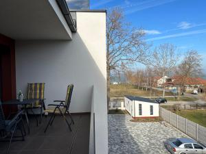 a balcony of a house with a table and a car at Scamard Apartman in Zamárdi