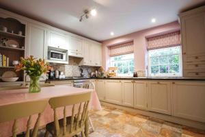 a kitchen with a table with a vase of flowers on it at Fabulous Folds Cottage in Curbar