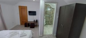 a bedroom with a shower and a bed with towels at Antic house in Predeal