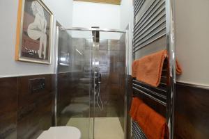La salle de bains est pourvue d'une douche en verre et de toilettes. dans l'établissement Mugnone house, à Florence