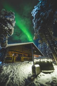 a cabin with the northern lights in the sky at Villa ArcticFox Levi in Kittilä