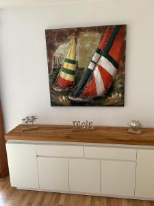 a painting of three sail boats on a wall at Fischkopp - exklusives & ruhiges Haus - ABC333 in Wismar