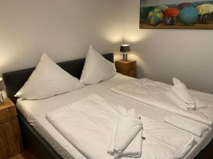 a bed with white sheets and pillows on it at Fischkopp - exklusives & ruhiges Haus - ABC333 in Wismar +12 photos