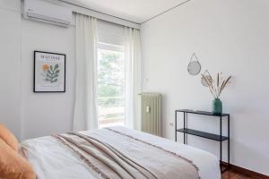 Habitación blanca con cama y ventana en Capacious 3BR apartment in the heart of Marousi, en Atenas