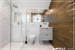 e bagno con servizi igienici bianchi e doccia. di Apartamenty Kuźnica "Morska 8" a Kuźnica