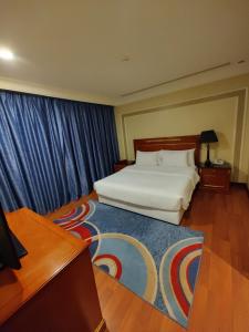 1 dormitorio con cama blanca y cortina azul en فندق كارم الخبر - Karim Hotel Khobar en Al Khobar