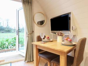 a dining room with a table and a tv at Yes Deer in Ashbourne