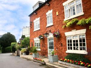 a red brick building with white windows and flowers at Yes Deer in Ashbourne