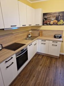 eine Küche mit weißen Schränken und Holzböden in der Unterkunft Finca Wismaria - Wismar s Wohlfühlplatz - ABC353 in Wismar