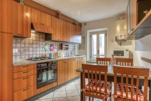 a kitchen with wooden cabinets and a table with chairs at San Marco Casa Vacanza in Osimo