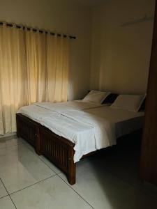 1 dormitorio con 2 camas con sábanas blancas en AADIS HOMES NEAR AIRPORT en Alwaye