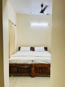 1 dormitorio con 1 cama en una habitación blanca en AADIS HOMES NEAR AIRPORT en Alwaye