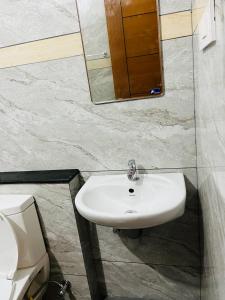 y baño con lavabo blanco y espejo. en AADIS HOMES NEAR AIRPORT en Alwaye