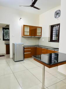 una cocina con nevera de acero inoxidable y armarios en AADIS HOMES NEAR AIRPORT, en Alwaye