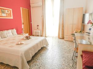 um quarto de hotel com uma cama grande e uma cozinha em Actinia Accommodation em Alghero