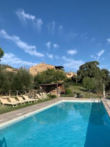 a swimming pool in front of a house at Borgo Montefreddo Toscana in San Casciano dei Bagni