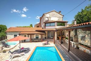 a villa with a swimming pool and a house at Villa Antoli in Tinjan