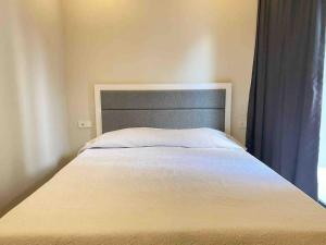 a bed in a bedroom with a gray headboard at Jasmin 4 in Alanya