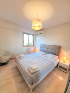 Un dormitorio con una cama grande y una lámpara de araña. en Petit Juas by Welcome to Cannes en Cannes