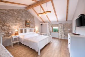 a bedroom with a white bed and a stone wall at Villa Antoli in Tinjan +39 photos