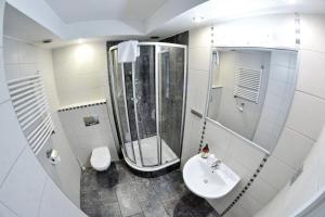 a white bathroom with a shower and a sink at Noclegi Bytom - OPAL in Bytom