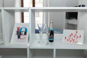 een witte plank met een fles wijn en glazen bij Domus Massimiliani Guesthouse in Rome +21 foto's