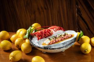 a bowl of food on a table next to lemons at Jumeirah Capri Palace in Anacapri