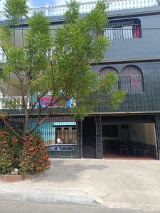 a building with a tree in front of it at Cambulos House in Melgar