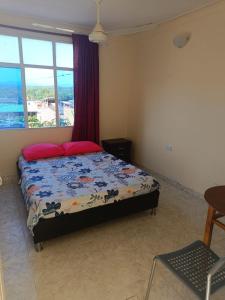 1 dormitorio con cama y ventana en Cambulos House en Melgar