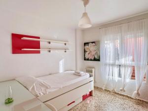 biała sypialnia z łóżkiem i oknem w obiekcie Espléndido Apartamento con Wifi w Grenadzie