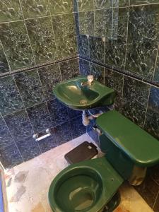 uma casa de banho com um WC verde e um lavatório em Cambulos House em Melgar