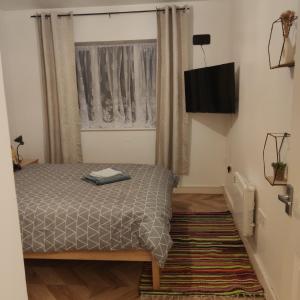 a bedroom with a bed and a flat screen tv at Comfortable stunning 2-Bed Apartment in Colchester in Colchester
