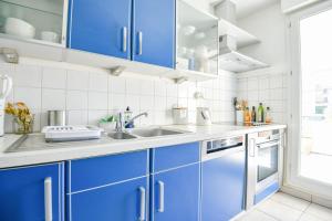 eine Küche mit blauen Schränken und einem Waschbecken in der Unterkunft Le Pharo - Plage des Catalans et métro Vieux-Port in Marseille