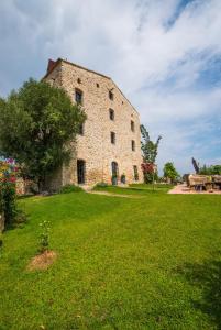 a large stone building in a field of grass at casa teppe rosse in Aléria