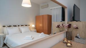 カランバカにあるNF Meteora Residenceの大きな白いベッドと鏡のある寝室