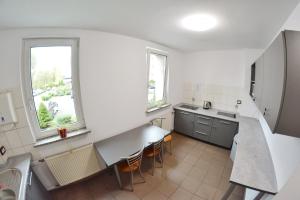 a kitchen with white walls and a table and chairs at Noclegi Bytom - OPAL in Bytom