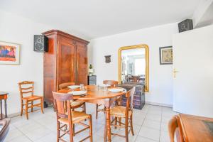 a dining room with a wooden table and chairs at Le Pharo - Plage des Catalans et métro Vieux-Port in Marseille