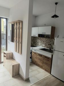 a kitchen with a white refrigerator and wooden cabinets at Jegenye apartments in Miercurea-Ciuc