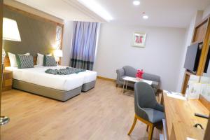 Pokój hotelowy z łóżkiem i biurkiem w obiekcie UNITED HOTEL INTERNATIONAL w mieście Jaunde