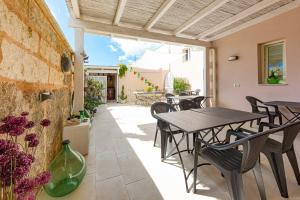 a patio with tables and chairs and a building at Capperi !! Holiday Rentals in Morciano di Leuca