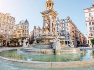 ヴィルールバンヌにあるHôtel Mercure Lyon Centre Charpennes Parc de la Tête d'Orの建物が立ち並ぶ都市の中心の噴水