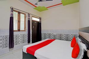 1 dormitorio con 1 cama con almohadas rojas en OYO Flagship S.K .hotel en Panchli