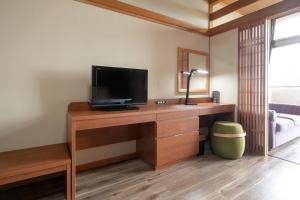 a room with a desk with a television on it at Ocean Resort Nomon長崎 in Nomo