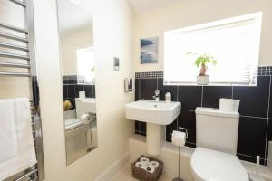 a bathroom with a white toilet and a sink at The Wellness Lodge- Gym, Table Tennis, Cinema, Parking and more! in Bath