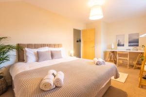 a bedroom with a bed with towels on it at The Wellness Lodge- Gym, Table Tennis, Cinema, Parking and more! in Bath