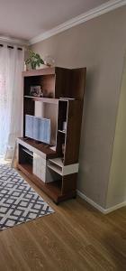 a living room with a tv on a book shelf at Apartamento praia centro itapema in Itapema