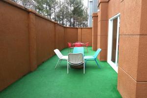 a patio with a table and chairs on a green floor at Baymont by Wyndham Lithia Springs Atlanta in Lithia Springs