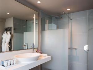 a bathroom with a sink and a shower at Cures Marines Hotel & Spa Trouville - MGallery Collection in Trouville-sur-Mer
