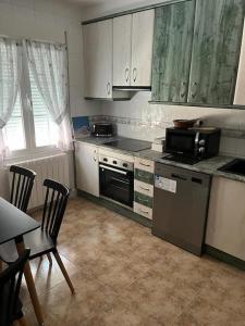 a kitchen with a stove and a microwave at Apartamento 7 adultos in Rueda