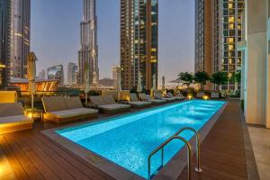 迪拜Manzil - Stylish 2BR in Downtown, Walking distance to Burj Khalifa & Dubai Mall的建筑物屋顶上的游泳池